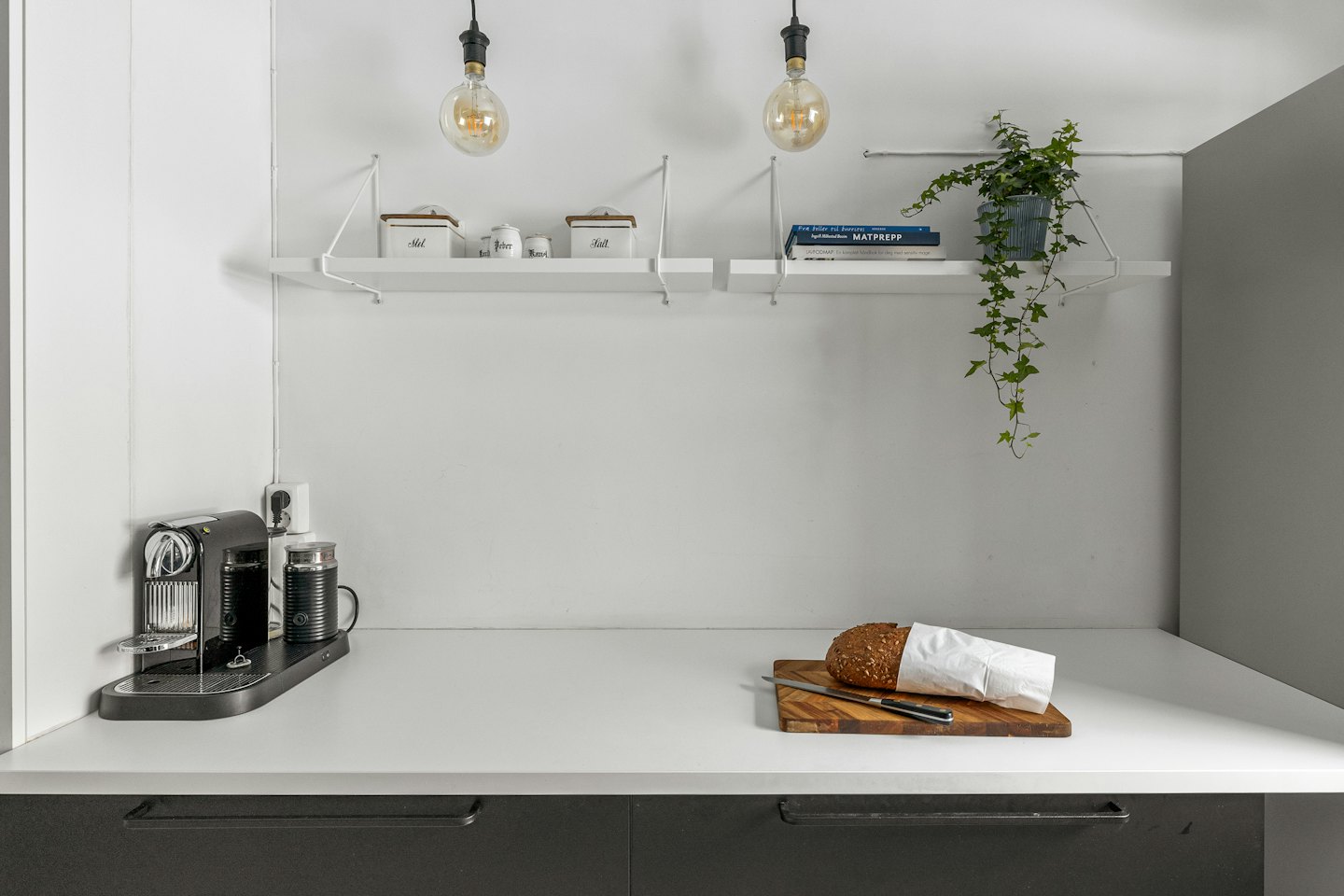 Kaffeemaschine und frisches Brot stehen auf einer modernen Küchenzeile.